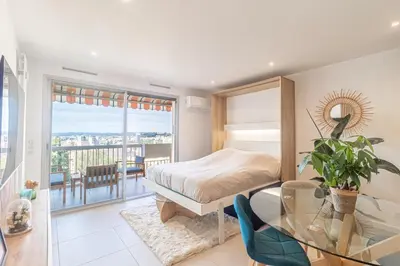a bedroom with a bed and a glass table at Studio cosy Vue mer in Nice
