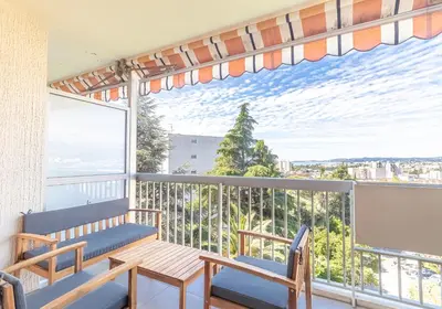 a balcony with a table and chairs and a large window at Studio cosy Vue mer in Nice