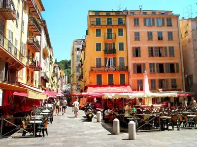 a city street with tables and chairs and buildings at Place Rossetti - Charming Apartment in Nice