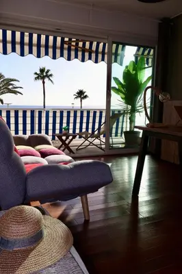 a living room with a couch and a view of the ocean at Appartement Pieds dans l'eau in Saint-Laurent-du-Var