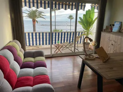 a living room with a couch and a view of the ocean at Appartement Pieds dans l'eau in Saint-Laurent-du-Var