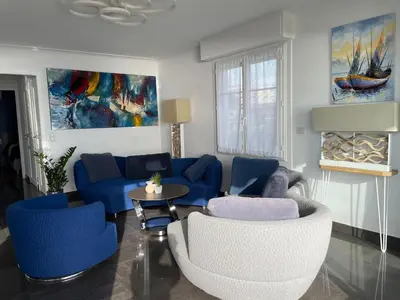a living room with blue couches and a table at Appartement Pieds dans l'eau in Saint-Laurent-du-Var