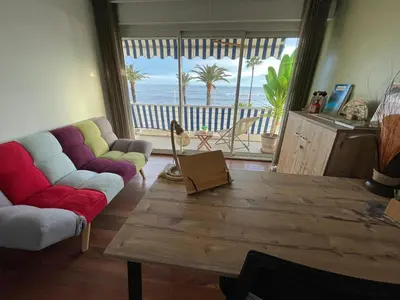 a living room with a couch and a table at Appartement Pieds dans l'eau in Saint-Laurent-du-Var