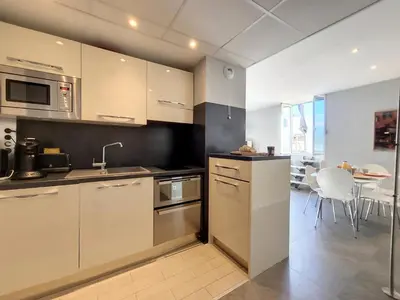 a kitchen with stainless steel appliances and a table at Nestor&Jeeves - ALPHONSE KARR TERRASSE - Hyper center - Close sea - Chic street in Nice