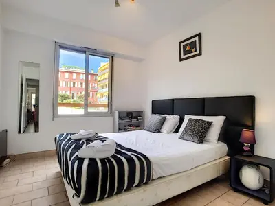 a bedroom with a large bed and a window at Nestor&Jeeves - CARDELINE TERRASSE - Very close sea - Spacious in Nice