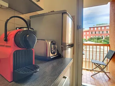 a kitchen with a stove and a refrigerator with a grill at Nestor&Jeeves - CARDELINE TERRASSE - Very close sea - Spacious in Nice