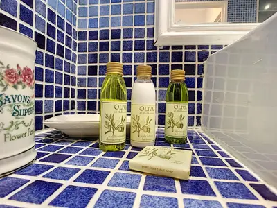 three bottles of wine on a blue tiled bathroom counter at Nestor&Jeeves - CARDELINE TERRASSE - Very close sea - Spacious in Nice