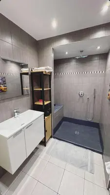 a bathroom with a shower and a sink and a tub at 2 pièces rénové avec magnifique vue mer et parking in Nice