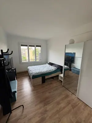 a bedroom with a bed and a mirror at 2 pièces rénové avec magnifique vue mer et parking in Nice
