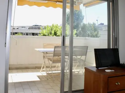 a balcony with a table and chairs on a patio at Appartement refait à neuf, climatisé - familles - FR-1-252A-143 in Cagnes-sur-Mer