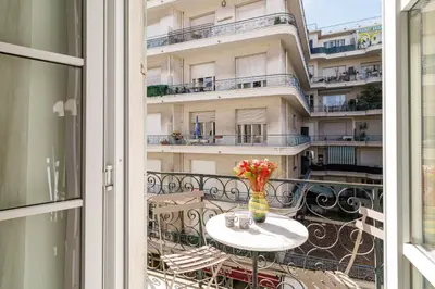 a table with a vase of flowers on a balcony at Wide & Central 3 Bdr - AC & Balcony in Nice