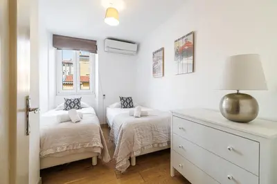 a white bedroom with two beds and a dresser at Wide & Central 3 Bdr - AC & Balcony in Nice