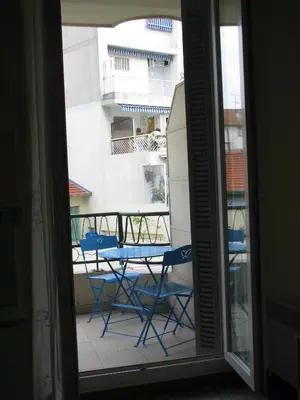 a balcony with chairs and a table and a building at Appartamento in rue Halevy in Nice