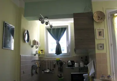 a kitchen with a sink and a window with a curtain at Appartamento in rue Halevy in Nice