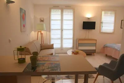 a bedroom with a bed and a table and a tv at Le 7 Augustin in Nice