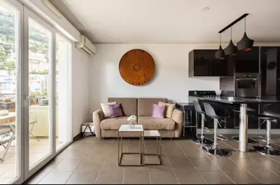 a living room with a couch and a kitchen at Carpe Diem in Beaulieu-sur-Mer