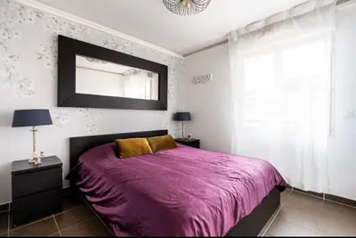 a bedroom with a purple bed and a mirror at Carpe Diem in Beaulieu-sur-Mer
