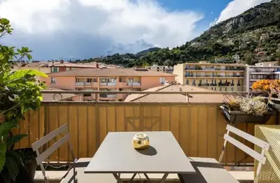a table with a vase on top of a balcony at Carpe Diem in Beaulieu-sur-Mer