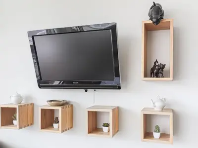 a flat screen tv hanging on a wall with wooden shelves at Apartment Saint Christophe by Interhome in Nice