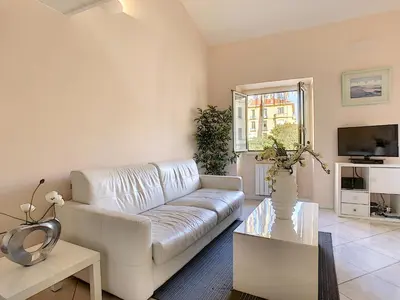 a living room with a white couch and a tv at Nestor&Jeeves - LE DUPLEX - Central - Very close sea in Nice