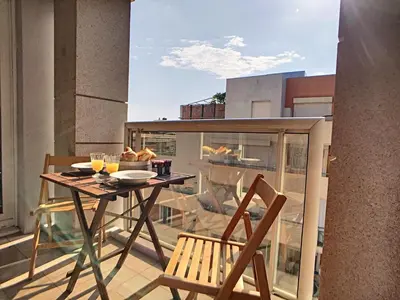 a balcony with a table and chairs on a balcony at Nestor&Jeeves - PALAIS RENOIR - By sea - Free parking in Nice