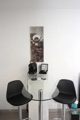 a room with two black chairs and a glass table at Villa Lympia in Nice