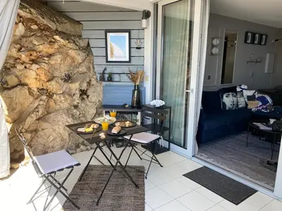 a living room with a table and a stone wall at Unique Apartment - Costa Plana in Cap d'Ail
