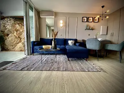 a living room with a blue couch and a table at Unique Apartment - Costa Plana in Cap d'Ail