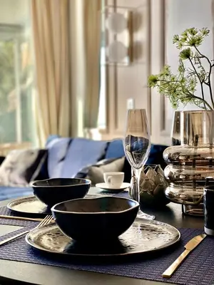 a table with plates and bowls and a glass of wine at Unique Apartment - Costa Plana in Cap d'Ail