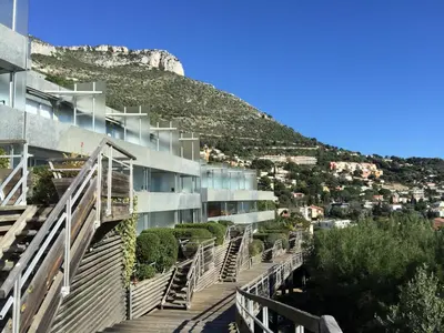 a building with stairs in front of a mountain at Unique Apartment - Costa Plana in Cap d'Ail