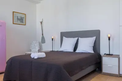a bedroom with a bed and a chair and lights at Palais Saint Pierre in Cagnes-sur-Mer
