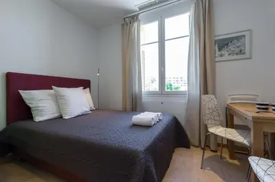 a bedroom with a bed and a desk and a window at Palais Saint Pierre in Cagnes-sur-Mer