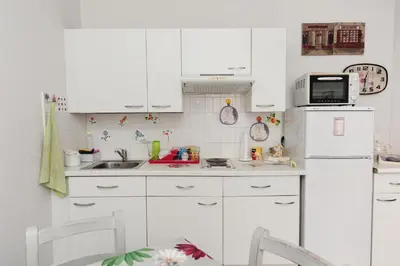 a kitchen with white cabinets and a white refrigerator at La Romantica Dante Five stars Holiday House in Nice