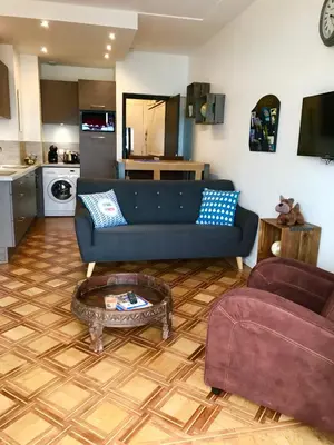 a living room with a blue couch and a table at Le Grand Sud in Nice