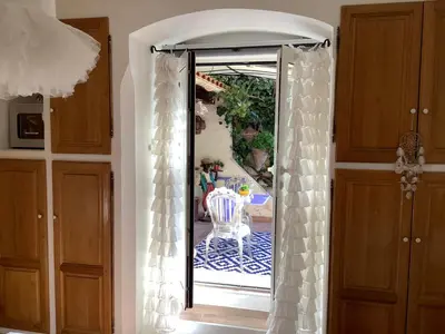 an open door to a patio with a table at Les Grimaldines - Maison d'Hôtes in Cagnes-sur-Mer