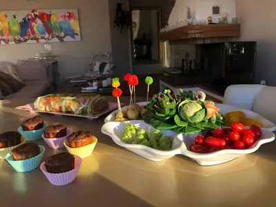 a table with a bunch of vegetables and cupcakes at Les Grimaldines - Maison d'Hôtes in Cagnes-sur-Mer