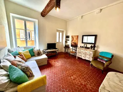a living room with a couch and a tv at Résidence Place Poullan in Villefranche-sur-Mer