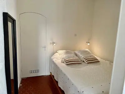 a bedroom with a bed with two pillows on it at Résidence Place Poullan in Villefranche-sur-Mer