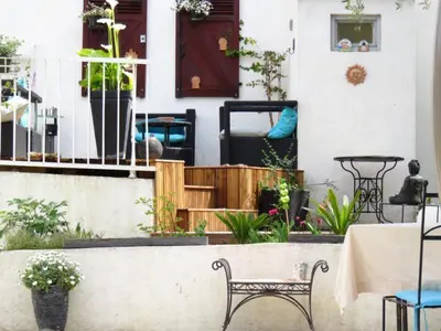 a patio with a table and chairs and plants at Hotel mon Soleil in La Gaude