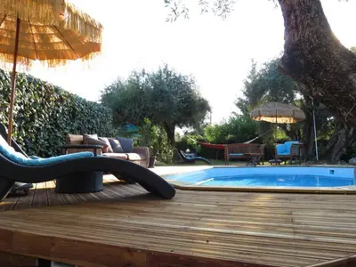 a deck with a swimming pool and an umbrella at Hotel mon Soleil in La Gaude