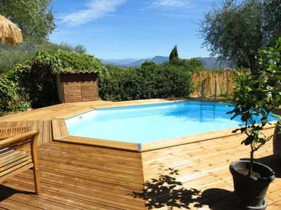 a large swimming pool on a wooden deck with a wooden deck at Hotel mon Soleil in La Gaude