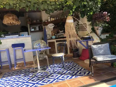 a patio with chairs and a table and a kitchen at Villa les grimaldines côte d Azur in Cagnes-sur-Mer