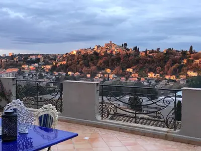 a balcony with a table and a view of a city at Villa les grimaldines côte d Azur in Cagnes-sur-Mer