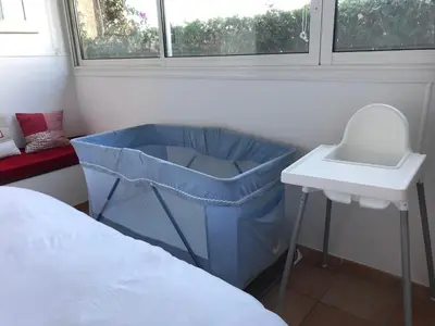 a bedroom with a crib and a sink next to a bed at Villa les grimaldines côte d Azur in Cagnes-sur-Mer