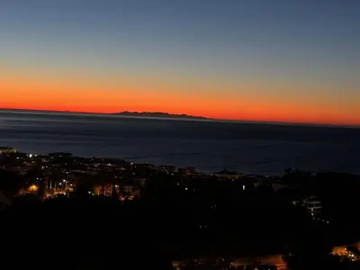 a sunset over the ocean and a city at Bellevue in Nice