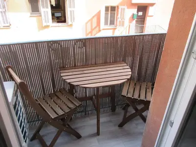 a wooden table and two chairs on a balcony at Nice Apartment Old Town in Nice