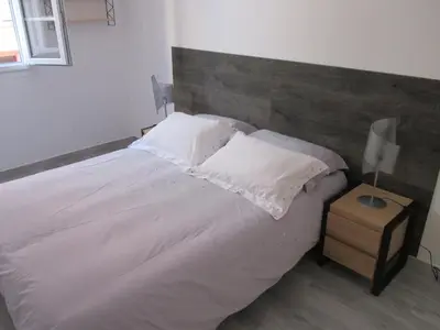 a bedroom with a large white bed with a wooden headboard at Nice Apartment Old Town in Nice