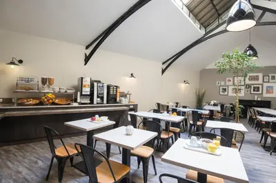 a restaurant with tables and chairs and a counter at Hotel Saint Gothard in Nice