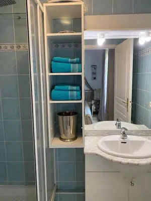 a bathroom with a sink and a shower with blue tiles at Appartement sur la Plage, Le Royal Beach in Saint-Laurent-du-Var