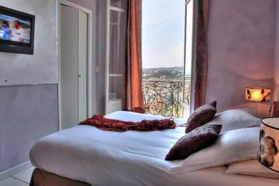 a bedroom with a bed with a large window at Le Panoramic Boutique Hôtel in Nice